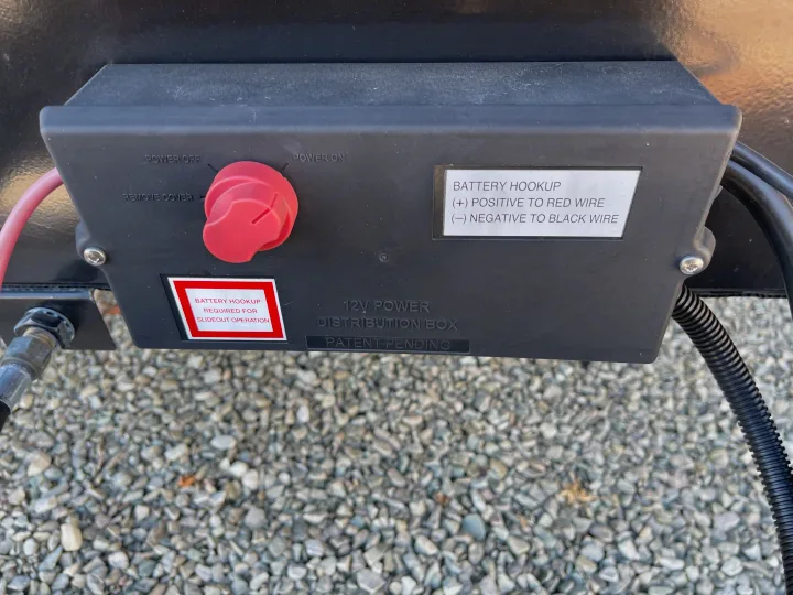 RV rental: A 12V power distribution box with battery hookup, a red power switch, and slideout operation instructions.. Crossroads RV Zinger Lite 2021