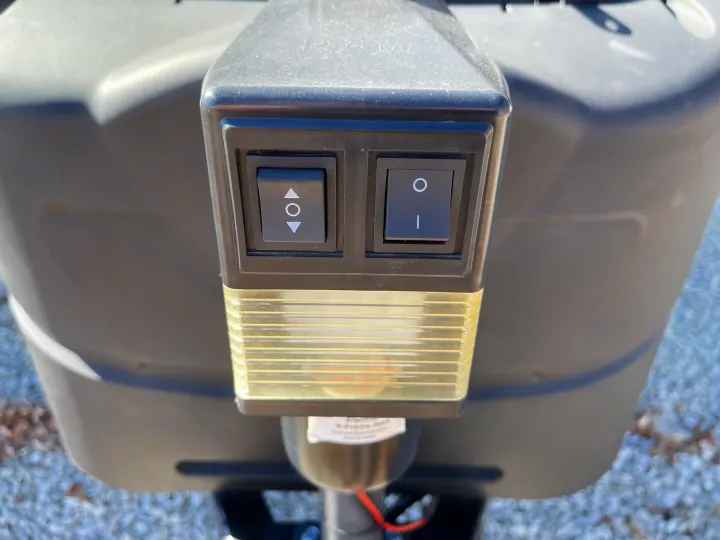 Closeup of an RV rental's electric tongue jack control panel. Features up/down and power switches, plus an integrated work light.. Crossroads RV Zinger Lite 2021
