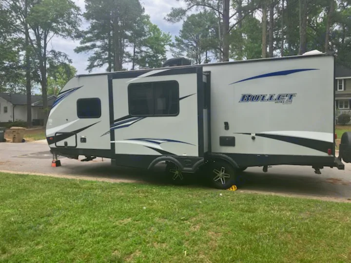 White Bullet Ultra Lite RV rental parked on a driveway, ideal for camping and travel. Set for your next adventure!. Keystone RV Bullet Ultra Lite 2018