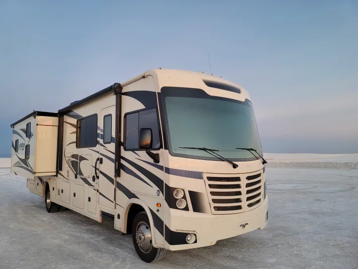 This spacious RV rental, a white motorhome with black accents, parked on a vast white plain, ready for adventure.. Forest River FR3 2020