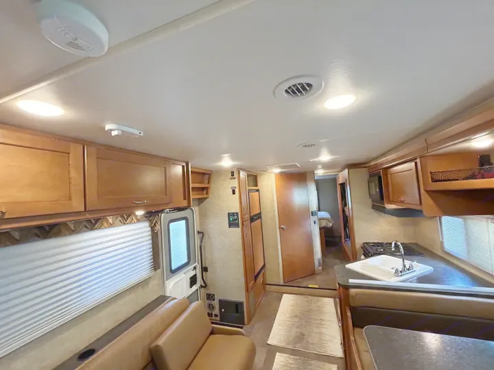 Inside this RV rental, find a functional kitchen, dining area, comfortable seating, and a private sleeping space.. Winnebago Minnie Winnie 2017