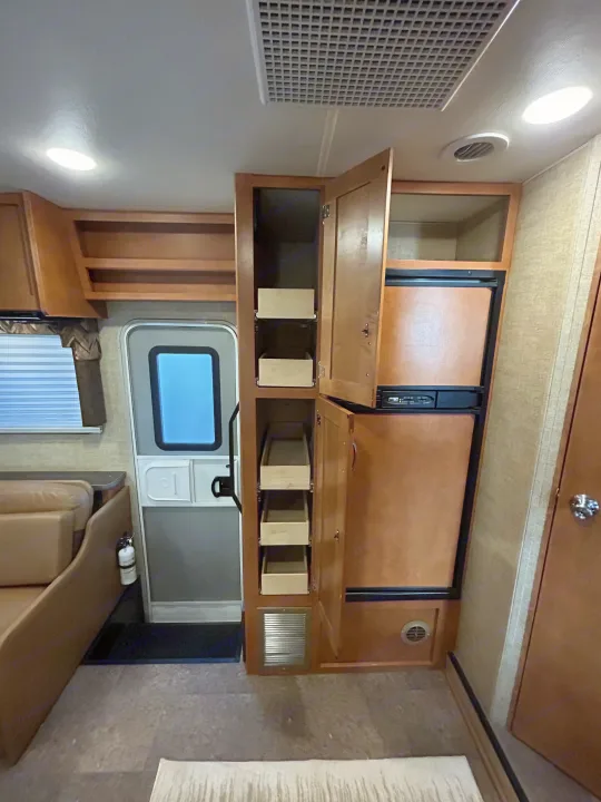RV rental interior with functional kitchen: refrigerator, pull-out pantry, and comfortable seating. Ready for your adventure.. Winnebago Minnie Winnie 2017