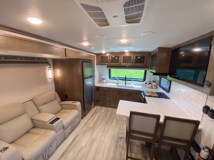 Step into this modern RV rental's bright interior with comfy recliners and a fully-equipped kitchen.. Forest River Rockwood Signature 2024