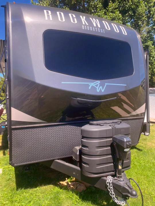 This Rockwood Signature RV rental travel trailer offers a large front window, propane tanks, and diamond plate accents.. Forest River Rockwood Signature 2024