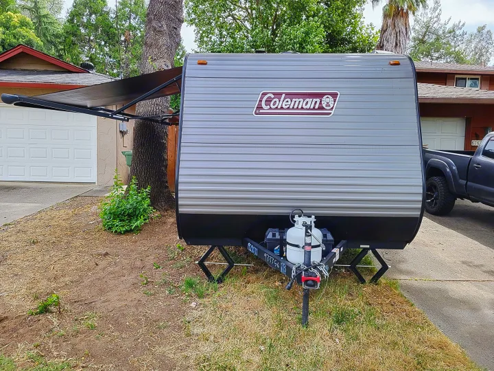 Coleman travel trailer RV rental parked with awning extended, ready for your next outdoor adventure.. Dutchmen Coleman Lantern LT 2023