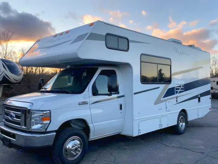 White Class C RV rental, a Wayfarer motorhome, parked outdoors under a sunset sky.. Tiffin Motorhomes Wayfarer 2021
