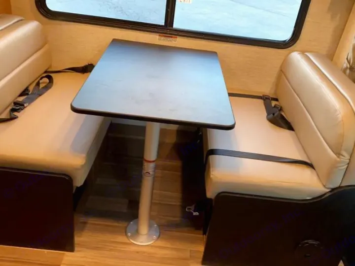 Inside this RV rental, a dinette offers two cushioned bench seats with seatbelts and a central table for meals or travel.. Tiffin Motorhomes Wayfarer 2021