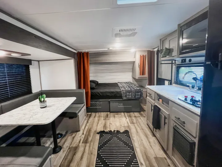 Modern RV rental interior: A spacious camper featuring a kitchen, dinette, and comfortable bedroom area with modern decor.. Dutchmen Lantern LT BB19 2024
