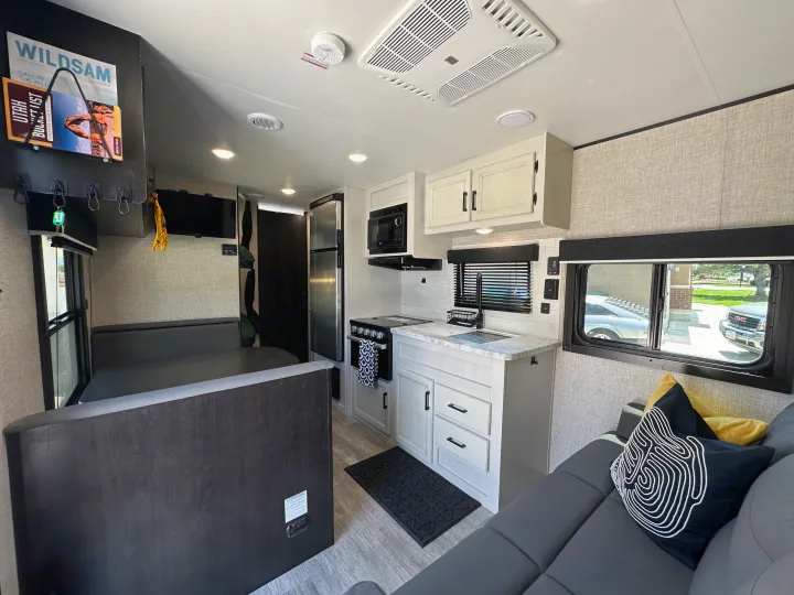 Well-equipped RV rental interior showcasing a full kitchen, comfortable dinette, and lounge area. Ready for your next adventure.. Jayco Jay Flight SLX Baja Edition 2023