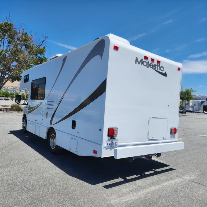 A bright white Majestic Class C RV rental is parked on asphalt under a clear blue California sky, ready for adventure.. Thor Majestic 2019
