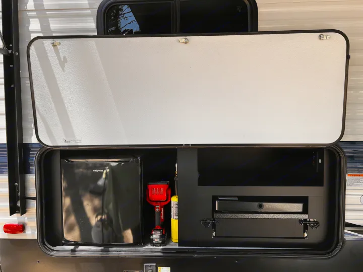 RV rental's outdoor kitchen features a mini-fridge, propane, and pull-out grill. Enjoy camping amenities.. Keystone RV Springdale 2022