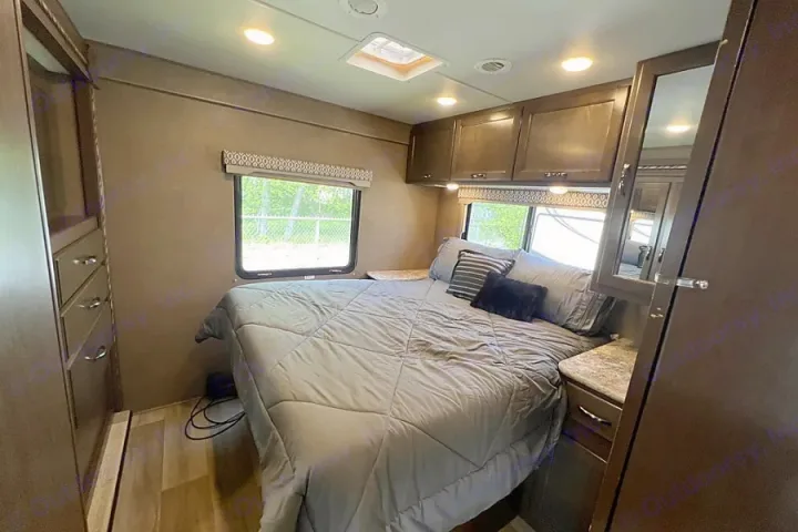 RV rental: A cozy and functional bedroom interior with a comfortable bed, overhead cabinets, windows, and a skylight.. Thor Motor Coach Freedom Elite 2017
