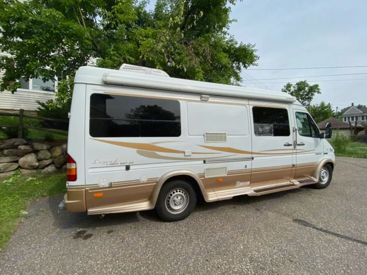 White and gold Legend Great West Van RV, a Sprinter-based camper, parked on asphalt. Perfect rv rental for your next adventure.. Mercedes-Benz Sprinter 2005