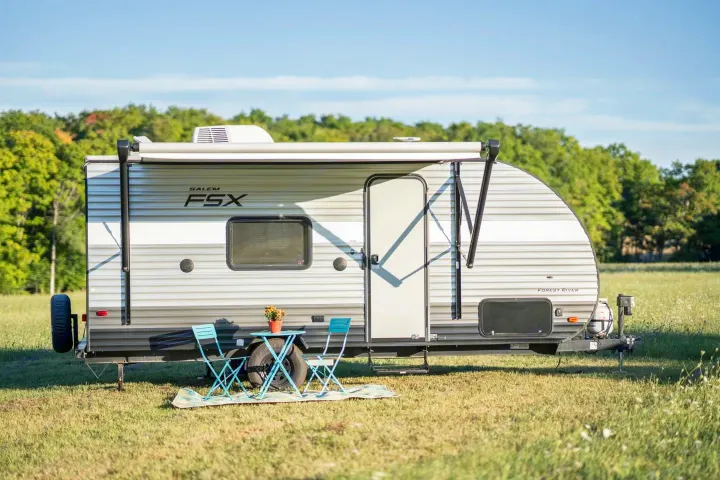 This Salem FSX Forest River travel trailer, an ideal RV rental, is parked in a sunny field, ready for outdoor adventures.. Forest River Salem Cruise Lite 2018