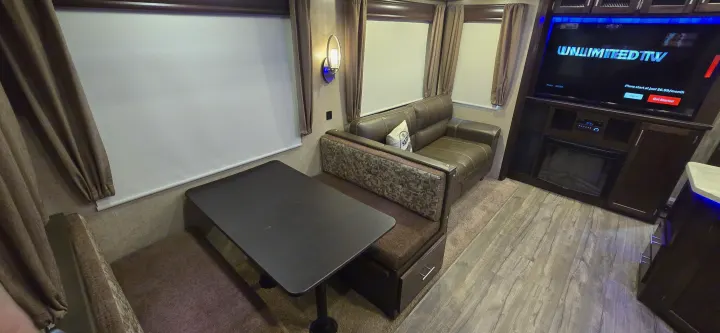 This RV rental offers a well-appointed interior with a dinette, comfortable sofa, and entertainment center including a TV and fireplace.. Forest River Cherokee Arctic Wolf 2018