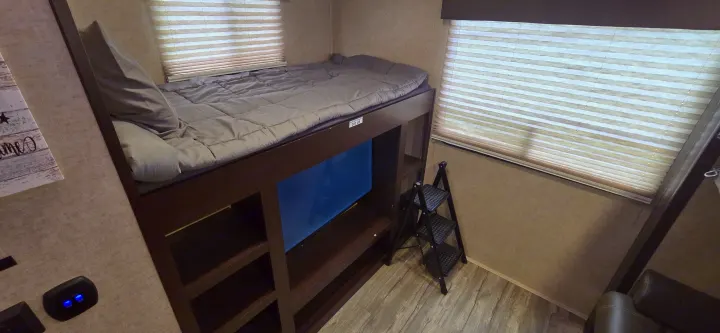 RV rental: space-saving bunk bed with a 300 LB limit, ladder, and built-in shelving for efficient living.. Forest River Cherokee Arctic Wolf 2018