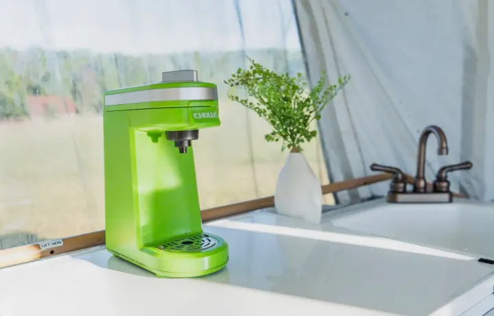 Enjoy fresh coffee in your RV rental! This bright green maker sits in a compact kitchen with a sink & scenic outdoor view.. Coleman Grand Tour Sun Ridge 1998