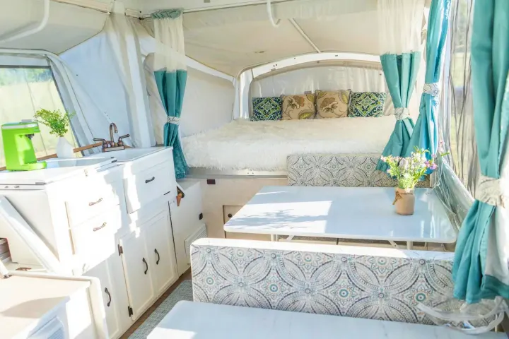 Bright, stylish pop-up camper interior: full kitchen, dining, and cozy bed. Perfect for your next rv rental.. Coleman Grand Tour Sun Ridge 1998