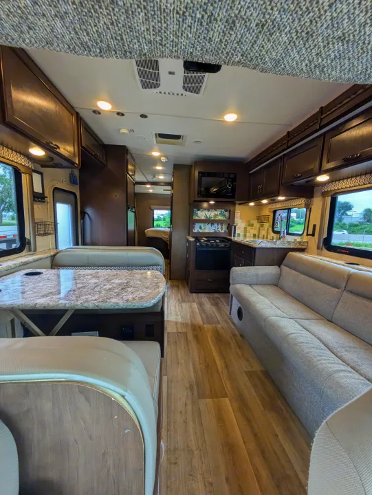 Spacious rv rental interior featuring a modern kitchen, comfortable dinette area, and cozy sofa for your journeys.. Thor Freedom Elite 2018