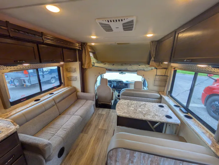 Spacious rv rental interior with living area, dining booth, overhead bunk, and full kitchen amenities, perfect for travel.. Thor Freedom Elite 2018