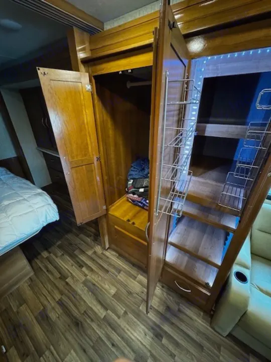 RV rental bedroom: functional design with a spacious closet, bunk beds with LED lights, and storage shelving.. Coachmen Mirada 2018