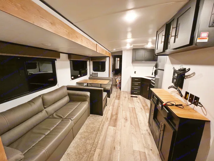 Step inside this modern rv rental, featuring a full living, dining, and kitchen setup. Perfect for travel.. Keystone RV Springdale 2022