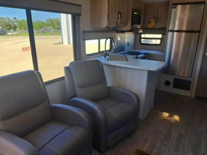 Spacious RV rental interior featuring recliners, a modern kitchen, and large windows for comfort on the road.. Forest River Aurora Aurora 2024
