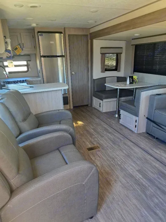 This RV rental interior offers a full kitchen, dining booth, and recliners for your adventures.. Forest River Aurora Aurora 2024