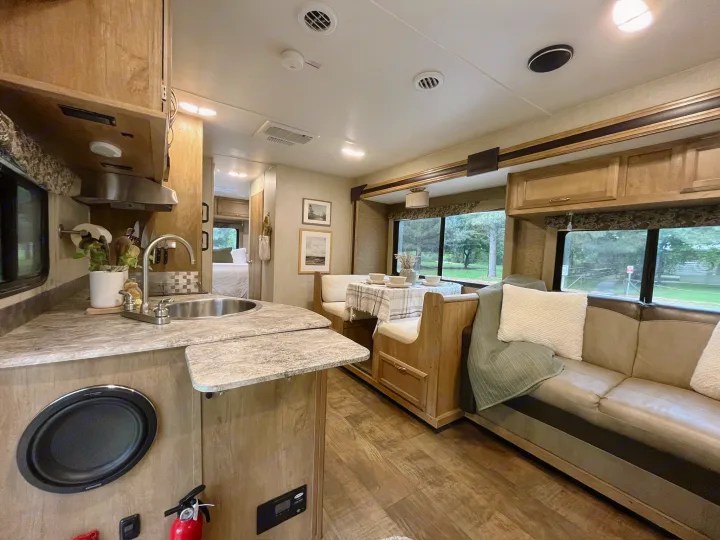 Spacious RV rental interior featuring a kitchen, dining booth, and comfortable living area with light wood finishes.. Gulf Stream Conquest 2017