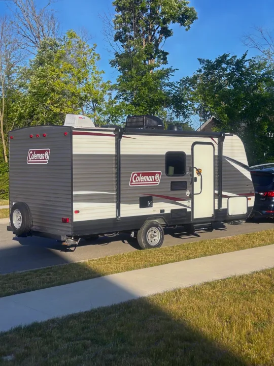 Grey Coleman travel trailer RV rental parked roadside. Ideal for your next camping trip.. Coleman Lantern 17FQ 2020