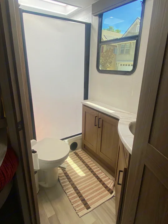 RV rental bathroom interior: Features a modern toilet, shower, and vanity. Perfect for travel comfort.. Alliance Delta 251BH 2024