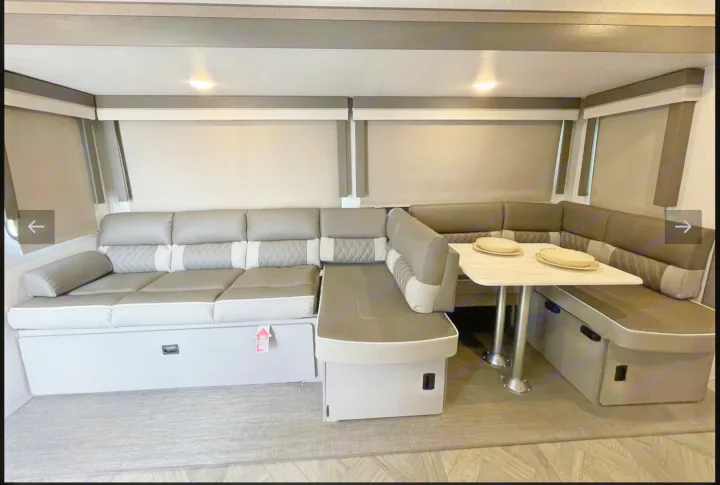 Spacious RV rental interior featuring a versatile U-shaped dinette with comfortable seating and smart storage, ideal for living.. Forest River Wildwood Platinum 2024