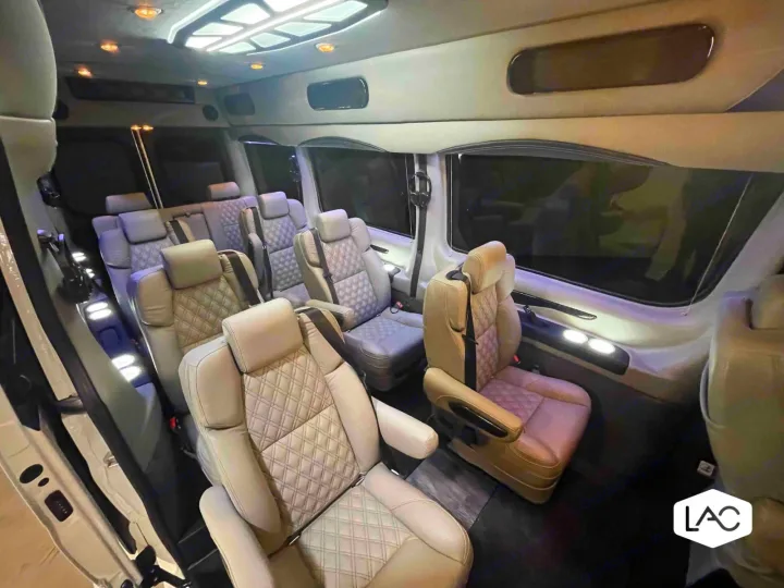 Spacious luxury RV rental interior: multi-row, light-colored diamond-quilted seats & bright ambient lighting.. Off Highway Van 2023 Mercedes-Benz Sprinter 2023
