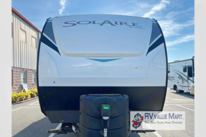 Front of a white Palomino Solaire travel trailer, ideal for an rv rental. Shows propane tanks.. Forest River Palomino Solaire 2023