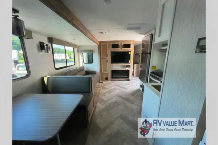 Explore this modern RV rental interior! Features include a dinette, comfy sofa, entertainment center, and full kitchen.. Forest River Palomino Solaire 2023