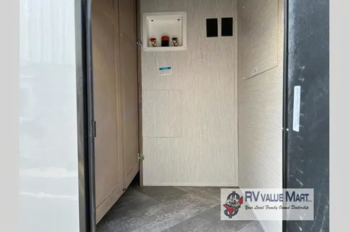 RV rental utility area with washer/dryer hookups, featuring water lines, drain, and electrical outlets for convenience.. Forest River Palomino Solaire 2023