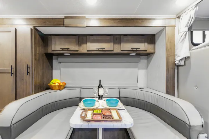 Enjoy a comfortable RV rental dining experience with a modern U-shaped dinette, perfect for meals and relaxation.. Coachmen Prism 2024