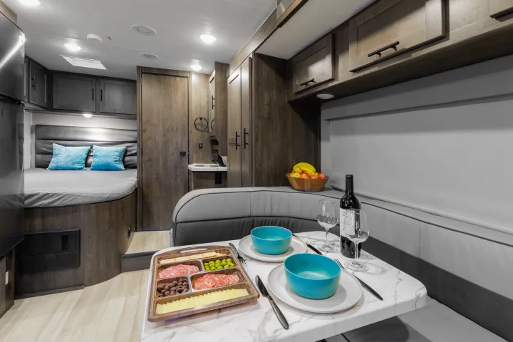 RV rental interior: cozy bedroom, dining area with charcuterie, wine, and fruit. Perfect for memorable road trips.. Coachmen Prism 2024
