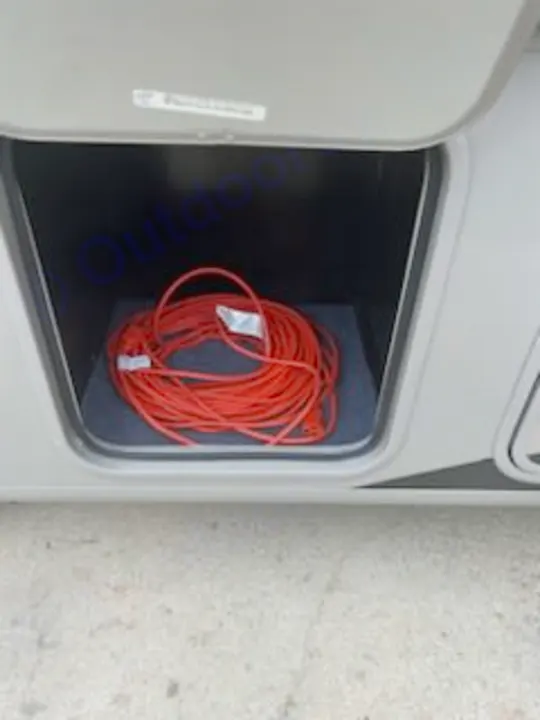 RV rental ready: A bright orange extension cord coiled in a clean, open storage bay of an RV.. Forest River Coachmen Pursuit 2017