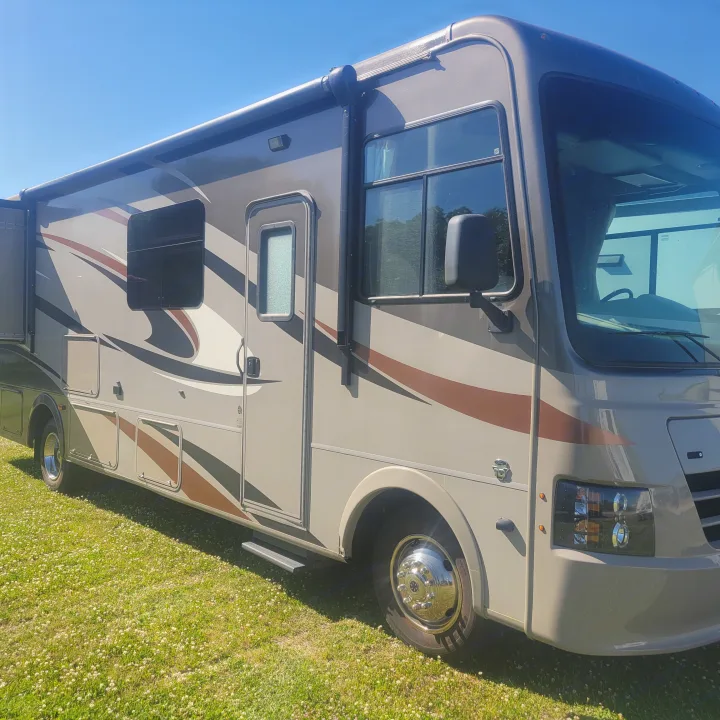 Experience freedom with this beautiful RV rental. A modern motorhome parked on green grass under a clear sky.. Forest River Coachmen Pursuit 2017