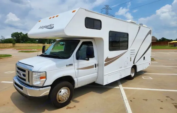 White Majestic RV rental. Class C motorhome parked in a lot under a partly cloudy sky, ready for your next adventure.. Thor Majestic 2019