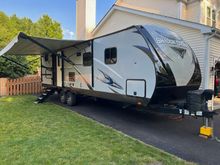 Large travel trailer with extended awning parked on a sunny driveway, ready for your next rv rental.. Cruiser RV Shadow Cruiser 2019