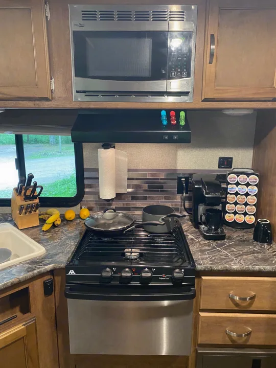 This RV rental kitchen has a microwave, range, sink, and coffee maker, fully equipped for adventures.. Keystone RV Springdale 2017