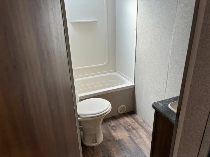 This RV rental features a compact bathroom with a toilet, small tub/shower, and sink vanity.. Keystone Springdale 2017