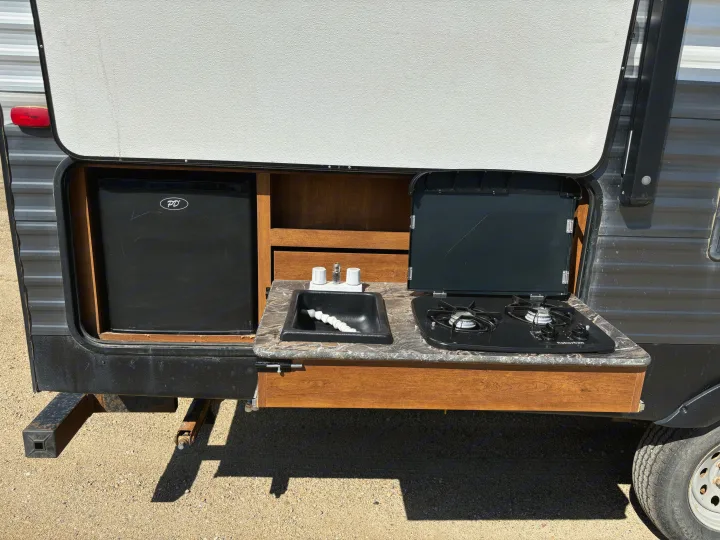 This RV rental offers a convenient pull-out outdoor kitchen with a fridge, sink, and stove.. Keystone Springdale 2017