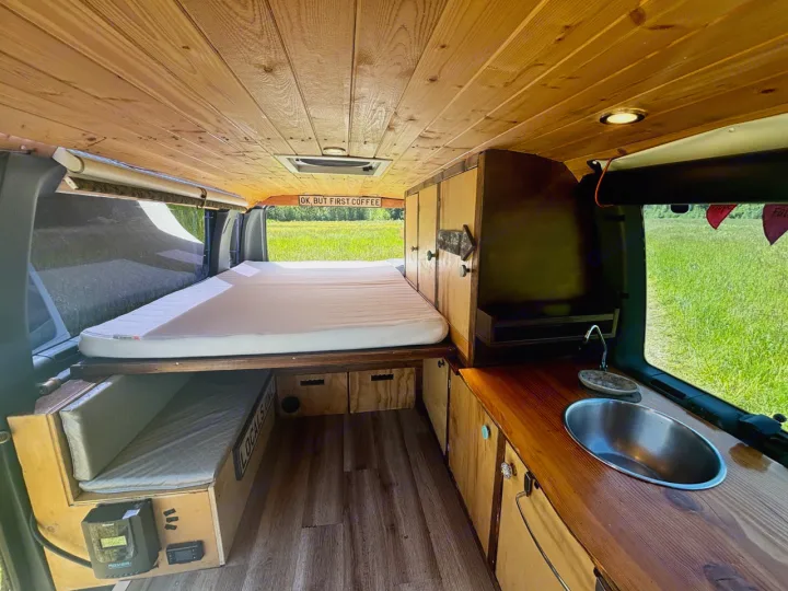 Inside this RV rental: wood-paneled interior, comfy bed, kitchen with sink, and smart storage for your next adventure.. Ford Ford E350 1996