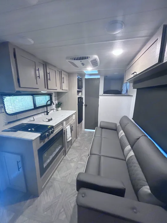 Inside a clean RV rental: modern kitchen, cozy sofa, and bunk area, all in a compact, well-lit space.. Forest River Salem Cruise Lite 2024
