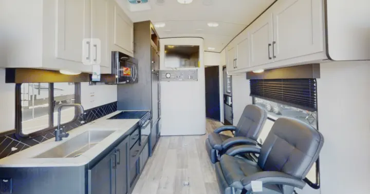 Spacious RV rental interior featuring a modern kitchen, comfortable living area with recliners, and entertainment system.. Heartland RVs Fuel Toy Hauler 2021