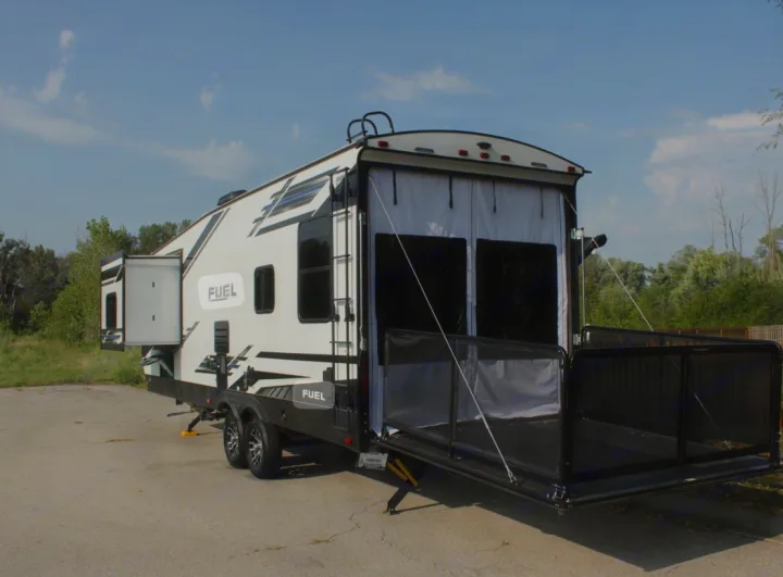 This white FUEL toy hauler RV rental shows its rear ramp converted into a patio deck, perfect for outdoor living.. Heartland RVs Fuel Toy Hauler 2021
