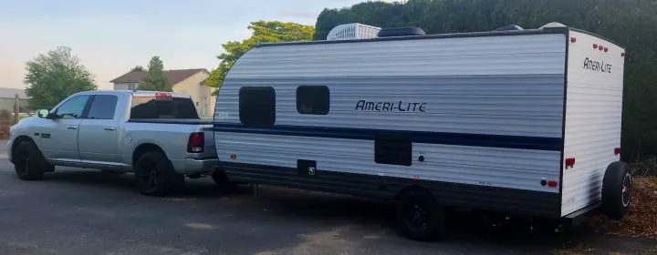 Silver Ram 1500 truck tows an Ameri-Lite travel trailer, perfect for your next RV rental adventure.. Gulf Stream Ameri-Lite Super Lite 2022